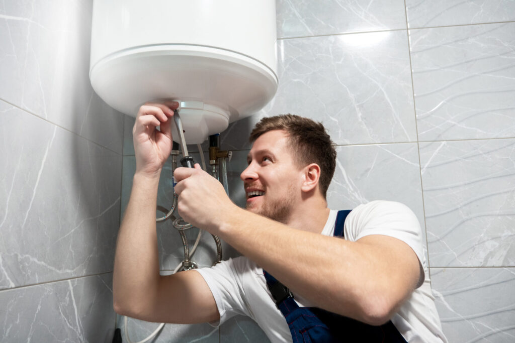 person repairs a leaking water heater.
