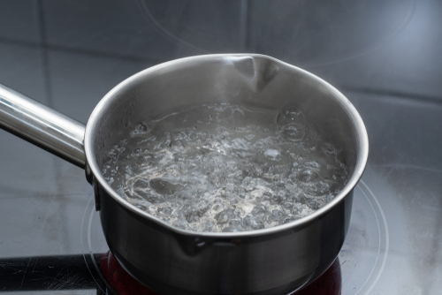 A pot of boiling water on a stovetop. 