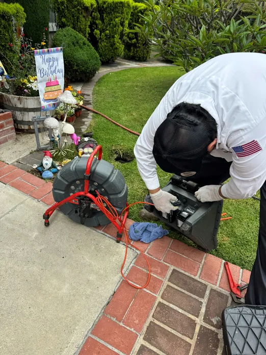 Plumber preparing hydro-jet equipment for drain cleaning