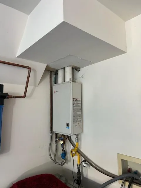 Indoor tankless water heater with venting and utility connections